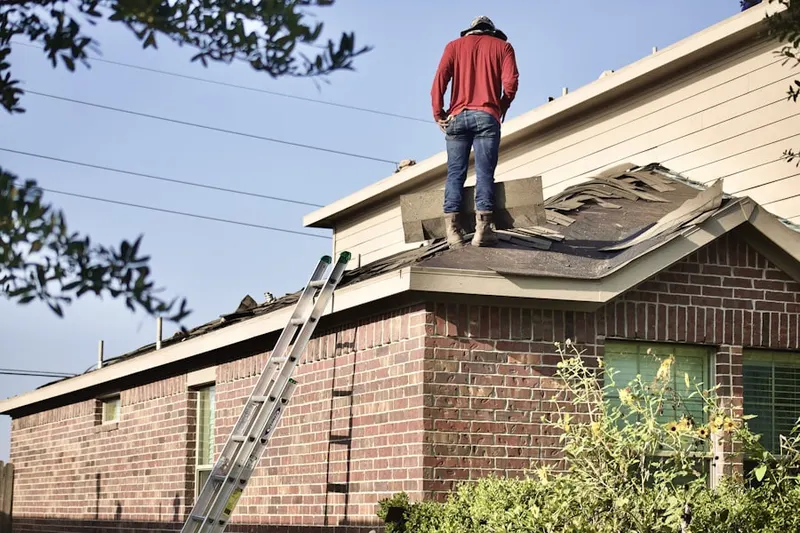 Professional roofer working on a residential roof in Ferrellton
